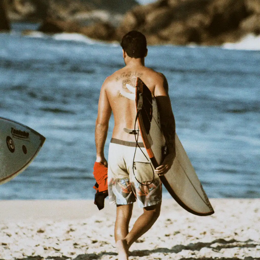Surfer Walking on Beach